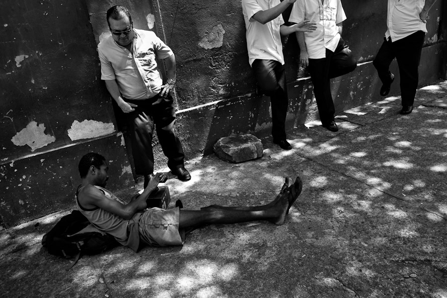 Brazilian shoe shiner works on taxi drivers' shoes on the street of Rio de Janeiro, Brazil.