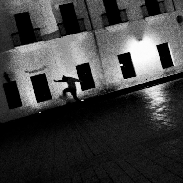 A Colombian skateboard rider jumps down the stairs in front of an old colonial house on the main plaza in Popayán, Colombia.