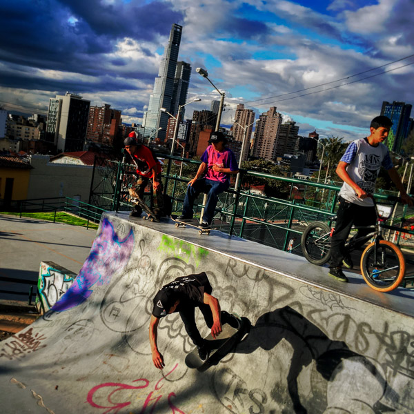 A Colombian skateboarder rides on a skateboard ramp, while being watched by his fellows, in the park of La Concordia, Bogotá, Colombia.