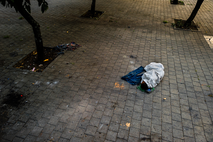 A Colombian drug consumer sleeps on the ground, lying next to his pants, in the street close to the center of Medellín, Colombia.