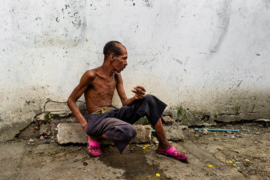 An Afro-Colombian man with a mental health disability talks to an imaginary person in a back street in Cartagena, Colombia.