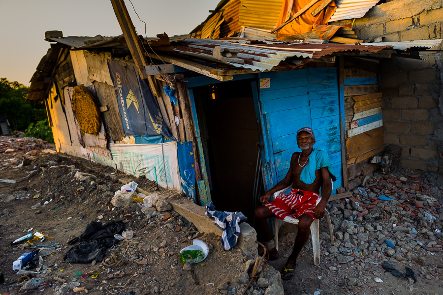 An Afro-Colombian man sits on a chair in front of his wooden house in Olaya Herrera, a low social class neighborhood in Cartagena, Colombia.