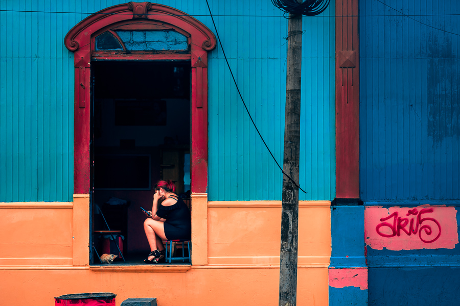 A Salvadoran sex worker looks at the phone screen while waiting for clients in a street sex bar in San Salvador, El Salvador.