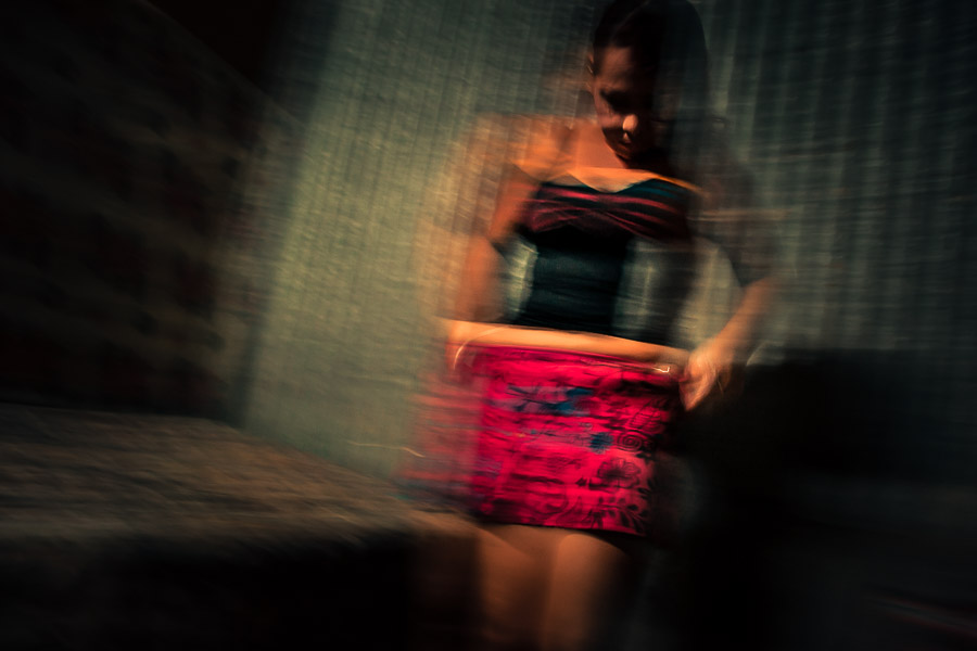A Salvadoran sex worker takes off her miniskirt in a rented room before providing sexual service to a client in San Salvador, El Salvador.