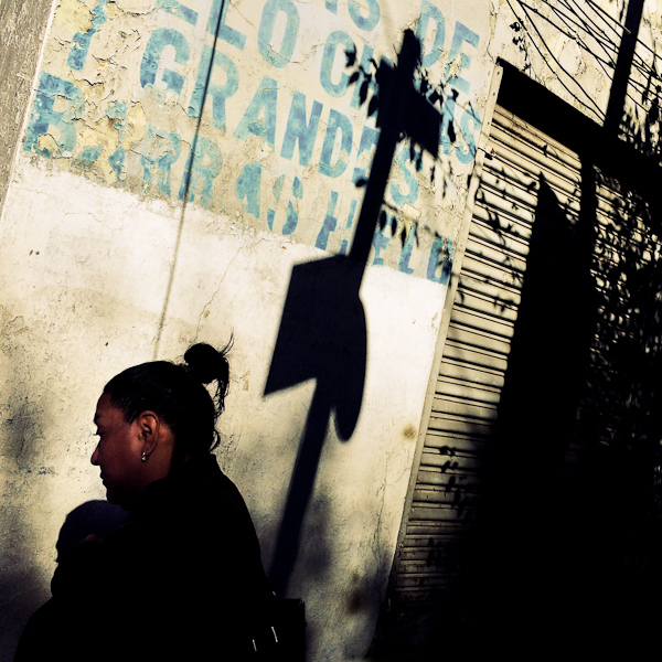 People walk around the street corner during a sunny morning in Buenavista, a neighborhood in Mexico City, Mexico.