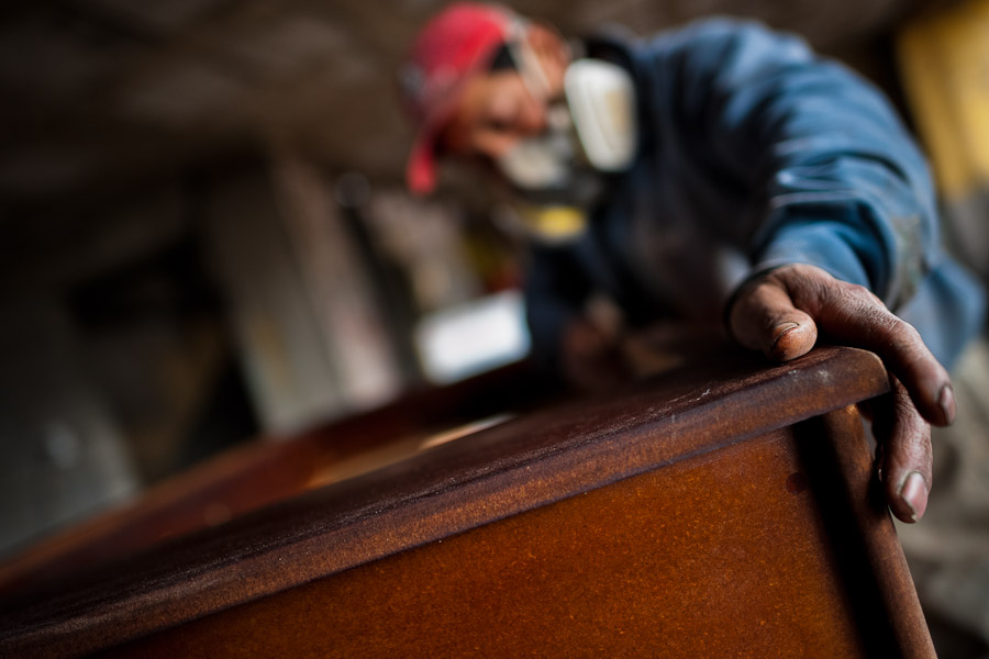 A carpentry worker polishes the chipboard case with a sandpaper machine at a table football workshop in Quito, Ecuador.