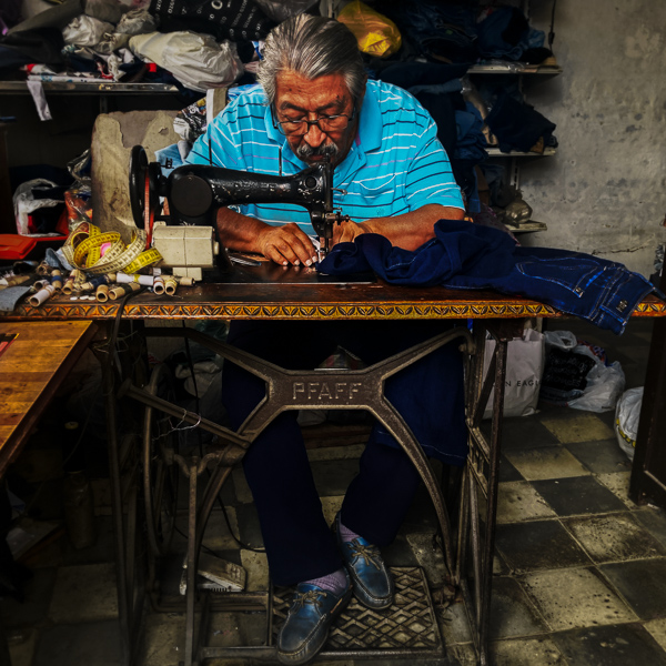 A Colombian tailor sews on a vintage sewing machine in his workshop in Cali, Colombia.