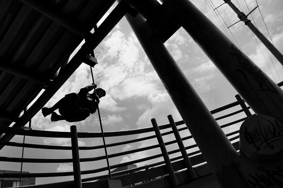 Cristian Lozano, a parkour runner from Tamashikaze team, spins around the footbridge railing during a free running training exercise in Bogotá, Colombia.