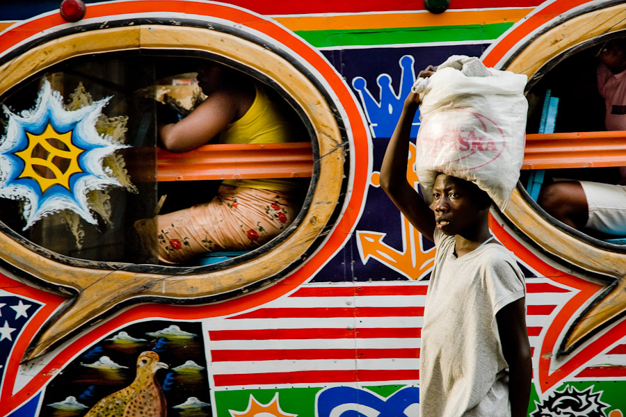 A Haitian street vendor offering water to the tap-tap passengers on the street of Port-au-Prince.