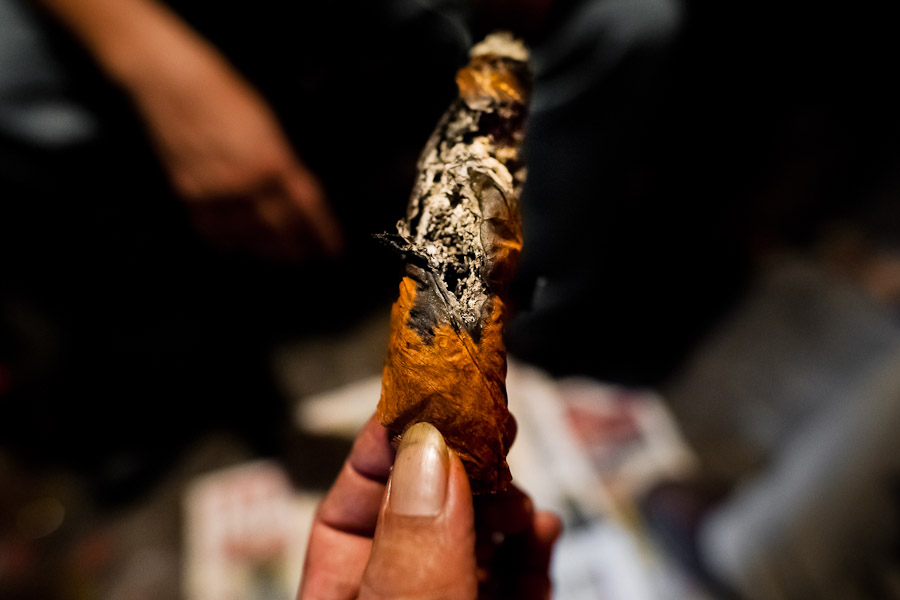 A Salvadorean ‘brujo’ (sorcerer) holds a burning cigar, predicting the future from shapes shown on the tobacco leaves, in a street fortune telling shop in San Salvador, El Salvador.