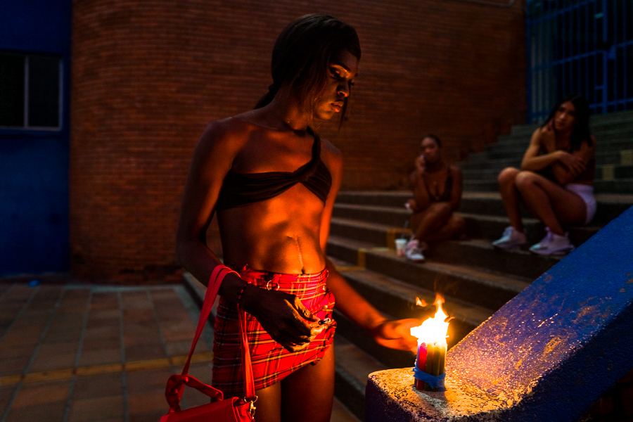 A Colombian transgender woman lights candles during the Day of the Little Candles (Día de las velitas) in the street in Cali, Colombia.