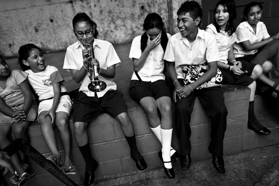 A school girl plays trumpet in front of the school in San Salvador, El Salvador.