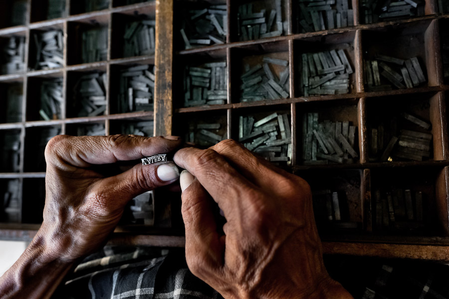 A Colombian master printer picks up typefaces from the type case in the print shop in Cali, Colombia.