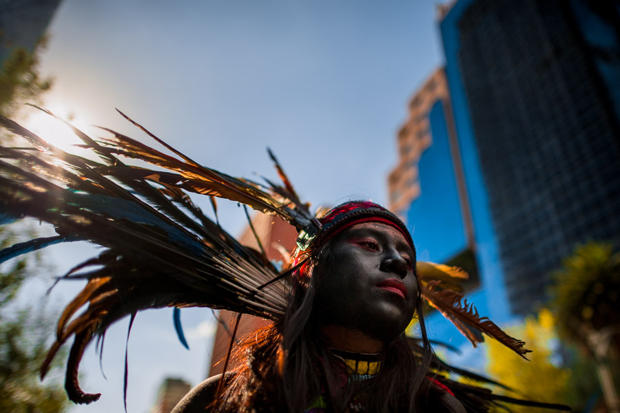 A Mexican girl, wearing a colorful feather headgear inspired by Aztecs, takes part in the Day of the Dead procession in Mexico City, Mexico.