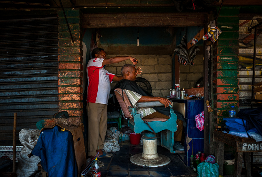 A Colombian hairdresser cuts a man’s hair in a barber shop in the market of Bazurto, Cartagena, Colombia.
