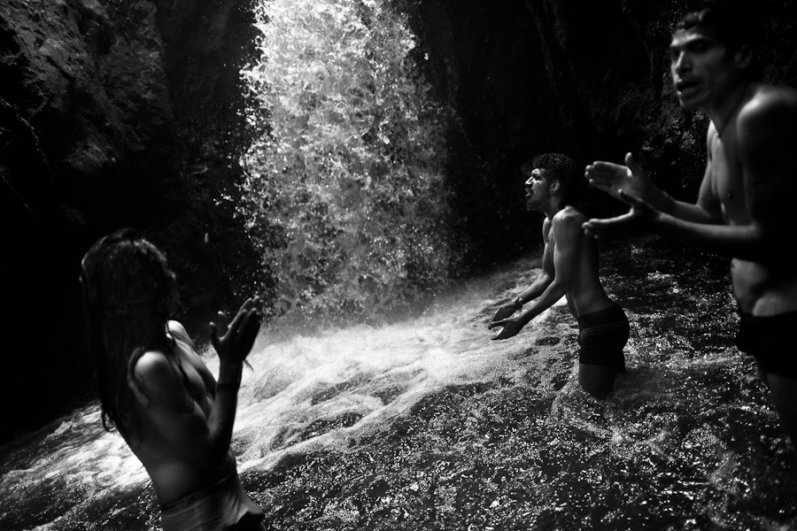 Young men worship the spirit of water during the private ritual held in the cave of Peguche waterfall, Ecuador.