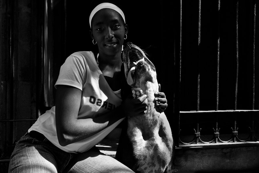 A Cuban woman poses for a picture with her amstaff dog during a sunny morning in Havana, Cuba.