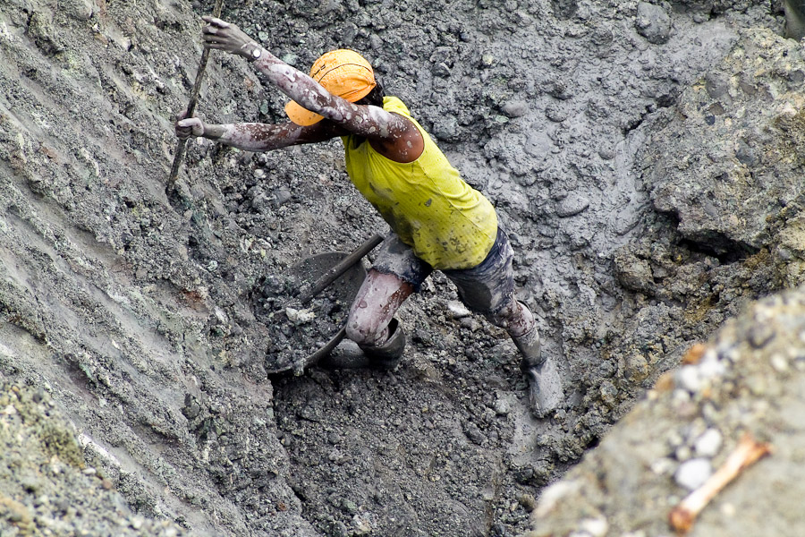 The woman goldminer digging goldbearing earth. They do not pay for panning, the mine owners let them glean in the hole after the rich part has been already excavated by machines.