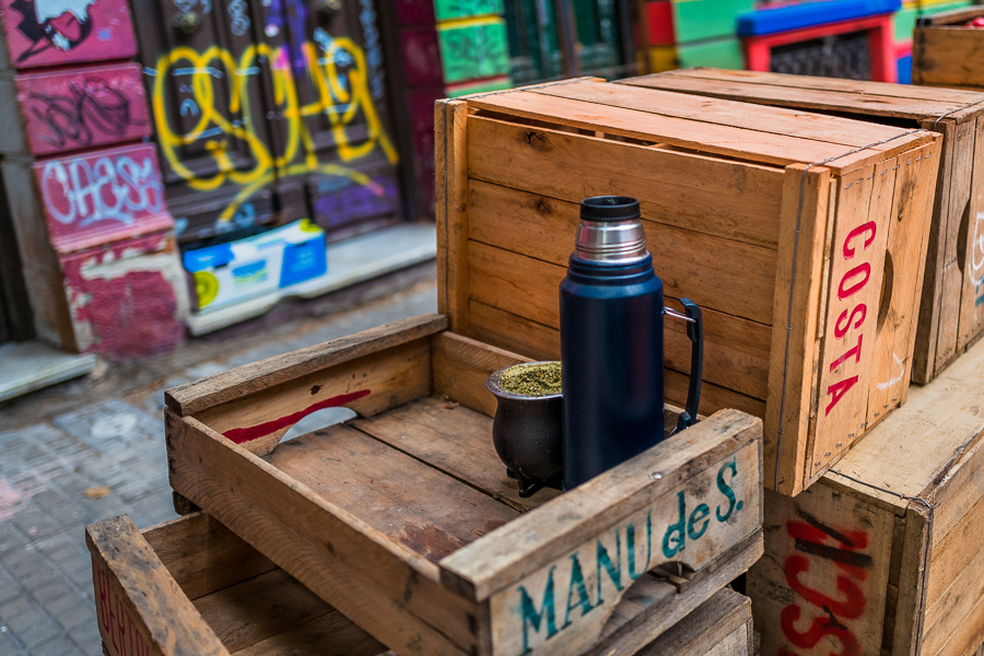A mate cup filled with yerba mate, along with a thermos of hot water, is seen placed on a pile of wooden fruit crates at the Tristán Narvaja street market in Montevideo, Uruguay.