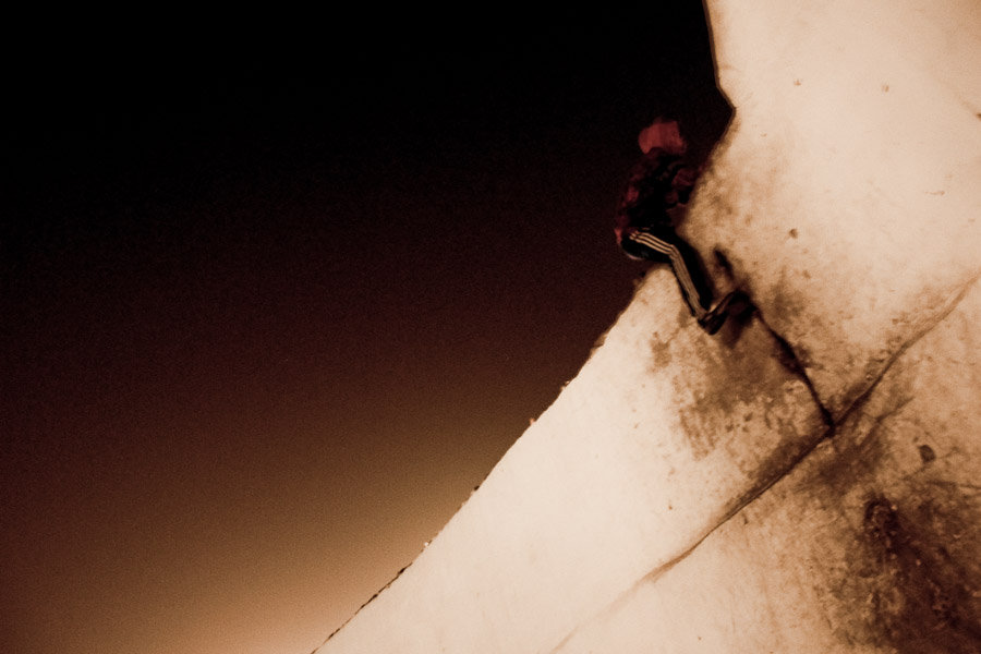 Moroccan immigrant climbs the wall of the port. The night makes the runaway a bit easier than during the day because customs officers tend to cheat the checkings in the early morning.